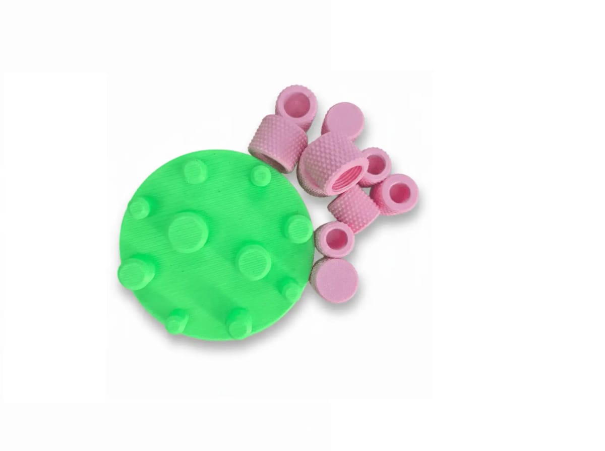 A green magnetic stand with pink knurled threaded caps