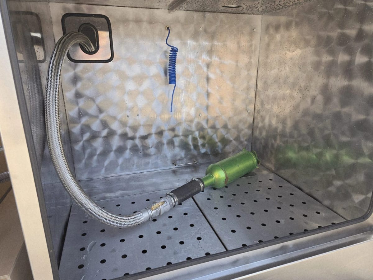 A filter connected to the braided wash hose inside a METClean V chamber